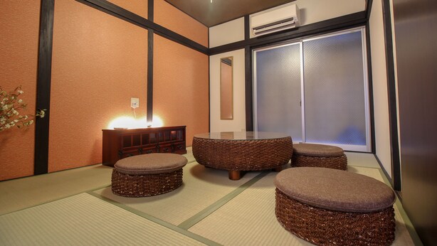 A traditional Japanese room with tatami flooring, a low table with cushions, and a sliding door. - JQ Villa Kyoto Higashikujo (Kyoto)