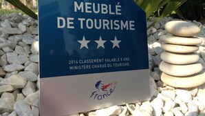 A sign indicating a tourism award for 2014, with the text "MEUBLÉ DE TOURISME" and "2014 CLASSEMENT VALABLE 5 ANS MINISTÈRE CHARGÉ DU TOURISME" along with the French flag and a logo.