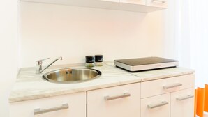A modern kitchen with a stainless steel sink, a digital scale, and a marble countertop. - Casa Laura Orange (Sant´Agnello)