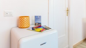 A white Comfee refrigerator with a patterned orange container and a magazine on top. - Casa Laura Orange (Sant´Agnello)
