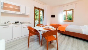 A modern, well-lit room with a dining table, chairs, a sofa, and a bed. - Casa Laura Orange (Sant´Agnello)