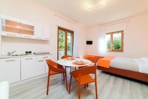 A modern, well-lit room with a dining table, chairs, a sofa, and a bed. - Casa Laura Orange (Sant´Agnello)