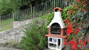 Eine Steinsäule mit einem kleinen, weiß-roten Outdoor-Ofen.