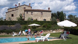 A stone building with a swimming pool, surrounded by grass and trees. - Tuscany. Lovely holiday home with swimming pool. (Castellina in Chianti)
