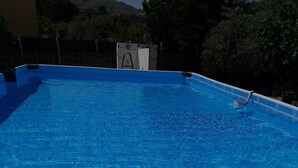 Una piscina azzurra e trasparente con una scala per accedervi.