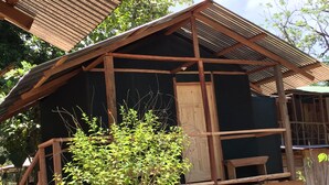 Eine Holzhütte mit einem Metalldach, umgeben von viel Grün.