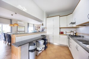 A modern kitchen with white cabinetry, a granite countertop, and a built-in oven.