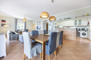 A modern kitchen with white cabinets, a built-in oven, and a microwave.