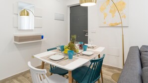 Ein moderner Essbereich mit einem weißen Tisch, blaugrünen Stühlen und einer Weltkarte an der Wand.