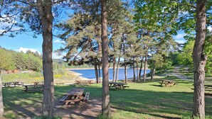 A park with picnic tables, trees, and a lake view. - chalet - Lapte (Lapte)