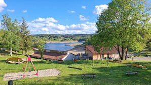 A lakeside property with a wooden cabin, a swing set, and a picnic area. - chalet - Lapte (Lapte)