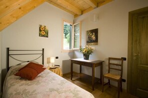 A bedroom with a bed, a desk, a chair, a window, and a door. - The 5 Sisters Residence (coreglia antelminelli)