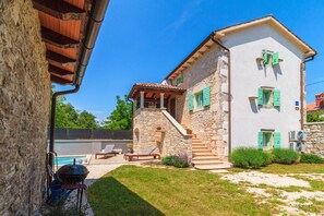 A stone house with a pool, outdoor seating, and a staircase leading to the upper floor. - Charming stone house with private pool and garden (Glavani, Barban)