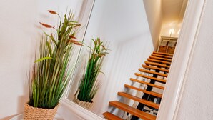 Una escalera con escalones de madera y una pared blanca.