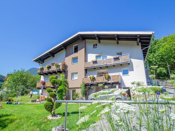 A multi-story building with balconies, a visible staircase, and a grassy area in front. - Cosy apartment for 4 guests with WIFI, TV and balcony (Pians)
