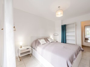 Cozy retreat with a neatly made bed, bedside table, and wardrobe.