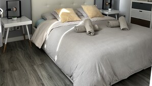 A modern bedroom with a grey and white color scheme, a tufted headboard, and a bedside table with a lamp. - Cocooning house - sea view - 4km from CANNES - 6 travellers (Golfe-Juan)