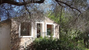 A rustic stone building with a small staircase leading to a door. - Flat with loggia in a charming 18th century family estate, quiet, with independant entrance. (Hyères)