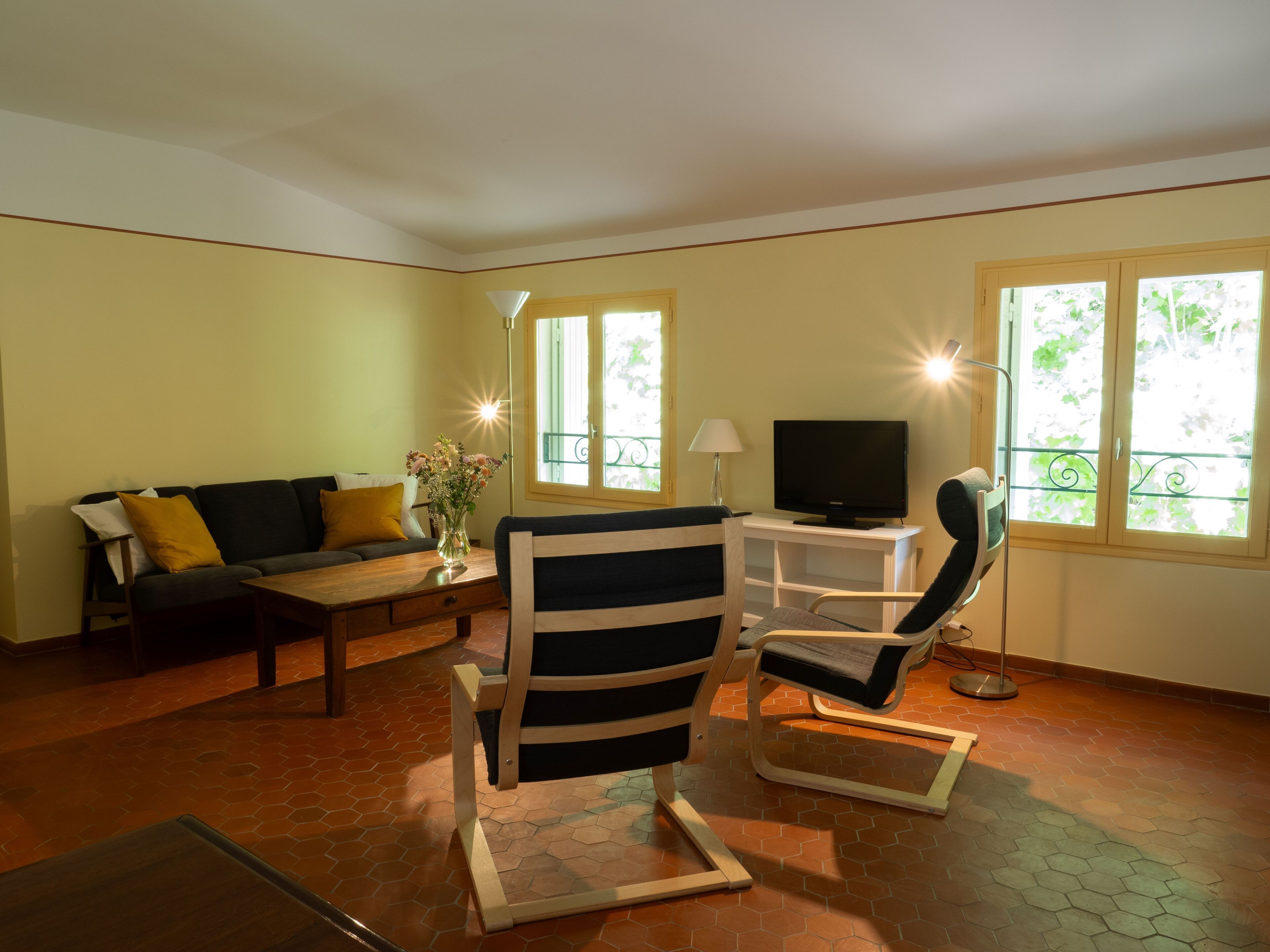 A living room with a sofa, a coffee table, a TV stand, and a chair.
