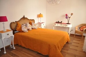 Een slaapkamer met een groot bed, twee nachtkastjes, een bureau en een stoel.