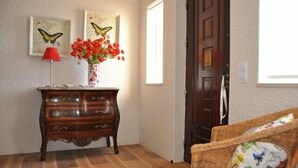 A wooden dresser with drawers, a red lamp, and a vase with red flowers. - Villa 500 meters from the sea with private saltwater pool in Meia Praia (Lagos)