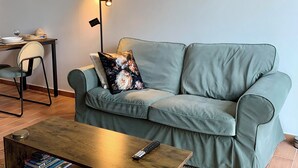 Una sala de estar con un sofá, una mesa de centro y un cuadro en la pared.