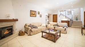 Ein Wohnzimmer mit Kamin, zwei Sofas, einem Couchtisch und einer Treppe.