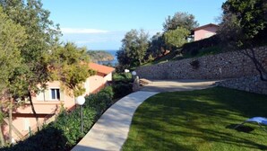 A curved pathway leading to a stone wall with a view of the sea. - Casa Serena - SERENA E (Capoliveri)
