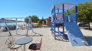 Une aire de jeux avec des structures d’escalade et une table entourée de chaises.