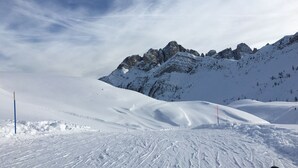 Ein mit Schnee bedeckter Skipisten mit Blick auf die Berge.