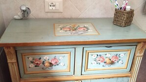 Ein altmodisches Kabinett mit floralen Verzierungen und einem gewebten Korb mit Zahnbürsten.