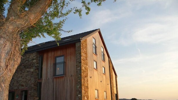 A rustic barn-style building with a stone facade and wooden exterior. - Spacious and comfortable gîte with garden and very nice view  (Nassogne)