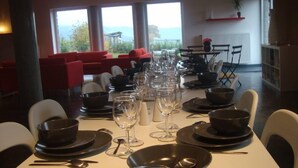 A dining area with tables set for a meal, chairs, and a view of the outdoors. - Spacious and comfortable gîte with garden and very nice view  (Nassogne)