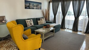 Un salon moderne avec un canapé vert, un fauteuil jaune et une table basse.