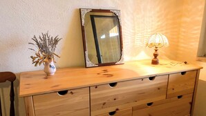 Un aparador de madera con varios cajones y un espejo con marco decorado.
