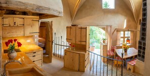 A rustic kitchen with wooden cabinets, a sink, and a dining area with a table and chairs. - Fürstenpalais holiday apartment in the tower of Schedling Castle near Lake Chiemsee (Trostberg)
