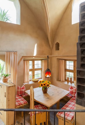 Ein rustikales Interieur mit Holztisch, Bänken und einer hängenden Laterne.
