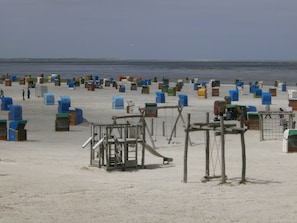 A beach with numerous colorful mailboxes and a wooden play structure. - Comfortable vacation home near the beach  (Dornumersiel)