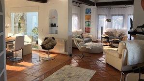 A spacious living area with a large window, a fireplace, and a cozy seating arrangement. - Exclusive private dream villa Finca holiday house with pool, Berg.-, sea view and many more. (El Ràfol d'Almúnia)