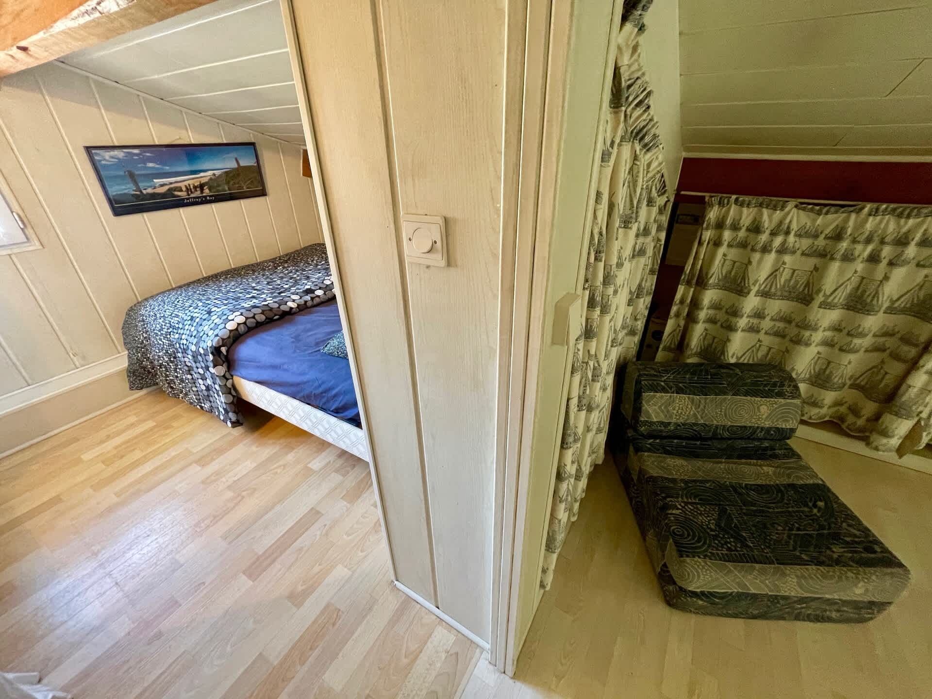 Ein Zimmer mit einem Etagenbett, einem kleinen Schreibtisch und einem Fenster mit Meerblick.
