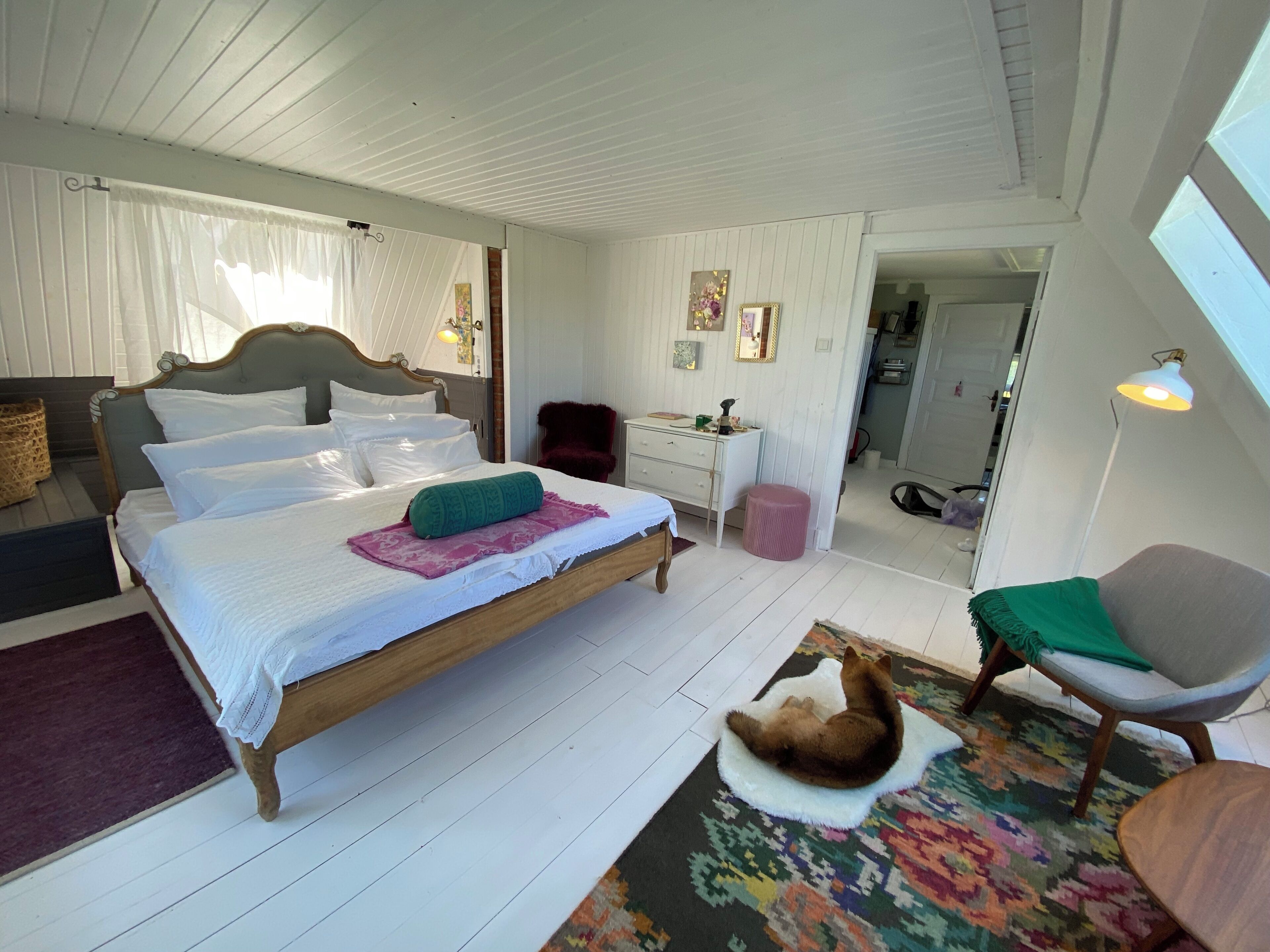 A bedroom with a wooden bed, a desk, a chair, and a rug.