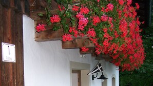 A rustic building with a wooden bench outside, a mailbox, and a hanging flower basket. - secluded, 300 year old landmarked Holiday Home, renovated (Bayern)