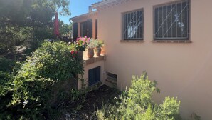 A house with a tiled roof, two windows with bars, and a small balcony with potted plants. - Côte d'Azur villa with stunning sea views for rent on the Giens Peninsula (Hyères)