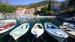 A marina with several small boats docked, surrounded by buildings with red roofs and a mountainous backdrop. - Room in Bol with Terrace, Air condition, WIFI (3758-4) (Bol)