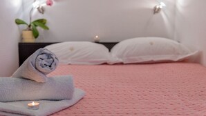 A neatly made bed with white pillows and a pink textured bedspread. A rolled-up towel is placed on the bed, and a small candle is lit on the side. - Room in Bol with Terrace, Air condition, WIFI (3758-4) (Bol)
