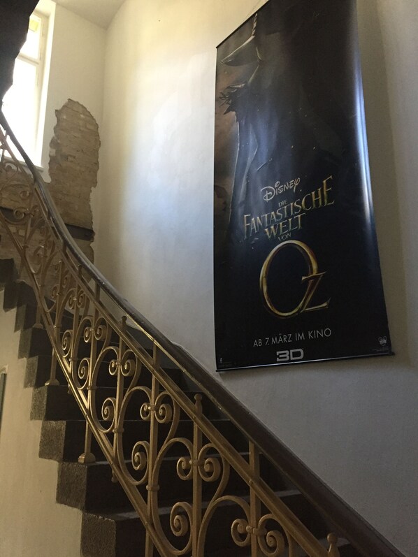 A staircase with ornate metal railings and a poster of 'Disney Fantasia Waltz' on the wall.