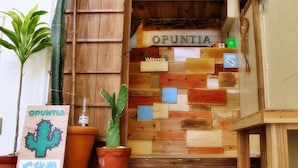 Een houten inkom met een bord waarop 