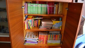 Ein Holzregal, gefüllt mit verschiedenen Büchern und Zeitschriften.