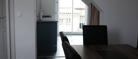 A modern kitchen with a dark countertop, a sink, and a window.