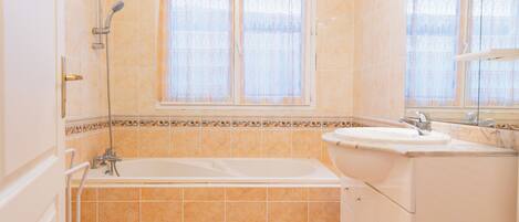 Un baño con bañera, lavabo y ducha.